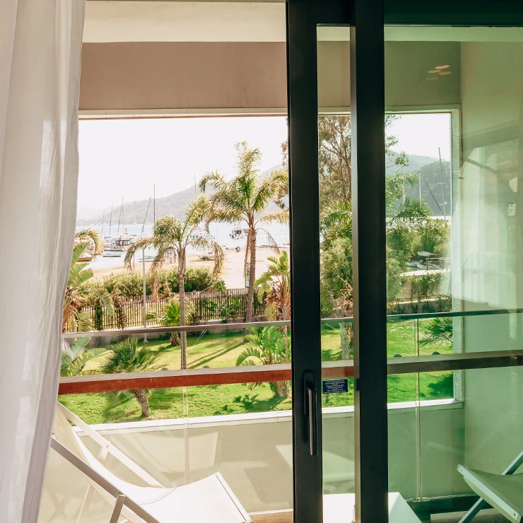 Junior Suite at D Resort Gocek with bright lounge and garden-view glass doors